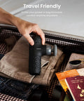 Person packing Mini Thermal Massage Gun With Heat Portable Deep Tissue Percussion Massager With Four Heads in suitcase