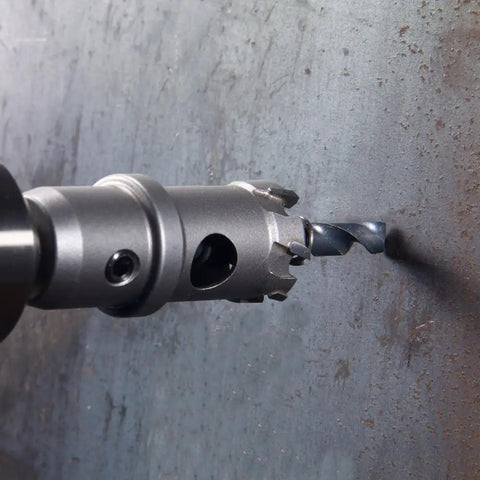 Close-up of 7 3/4 Inch Tungsten Carbide Tipped Hole Cutter drilling into steel, showing bit detail and precision cutting.