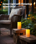 Lit Outdoor Solar Pillar Candles 3x6 Inches Waterproof on patio with dusk-to-dawn sensor flickering near chair for Halloween decor
