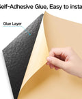 Self-adhesive layer of Twelve Pack Peel And Stick Acoustic Wall Panels High Density Sound Proof Foam Tiles Black shown in hand.