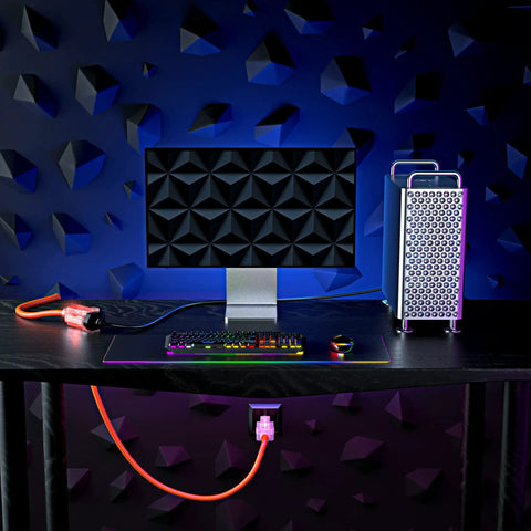Locking Extension Cord With Lighted Power Indicator, 100 Feet, Orange, 16 Gauge SJTW beside computer setup
