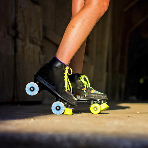 Person skating with black skates featuring Lit Up Roller Skate Wheels 4 Pack Blue LED Quad Wheels For Outdoor Skating