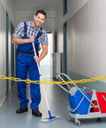Man cleaning hallway with 200 ft yellow plastic chain barrier for crowd control and event decor blocking access