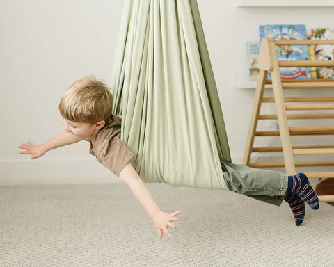 Child enjoying the Ultimate Chill Cotton Sensory Cocoon Swing For Kids Autism And Adhd Therapy Support Indoor Outdoor Hammock.