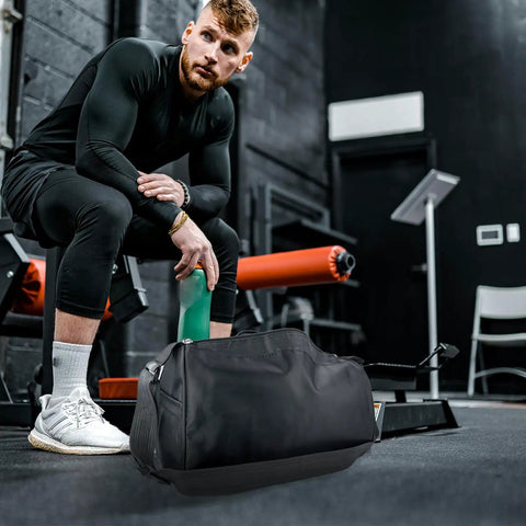 Foldable Waterproof Travel Duffle Bag For Gym And Beach resting on gym floor with man sitting beside it