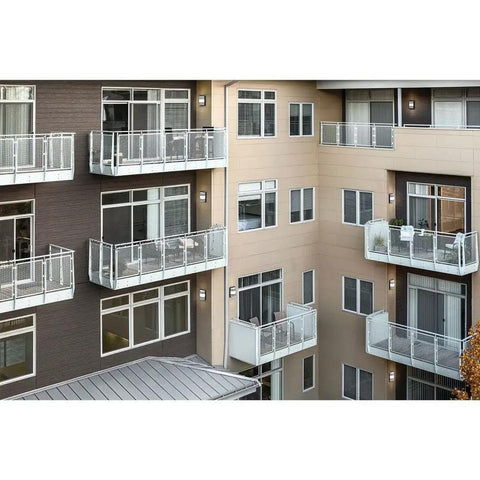 Apartment building with Outdoor Wall Light LED 13 Inch Textured Black With Integrated 3000K Glow, illuminating balconies.