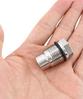 Stainless steel fuel rail plug valve, side view, hex end with black O-ring, M20x1.5, held in hand