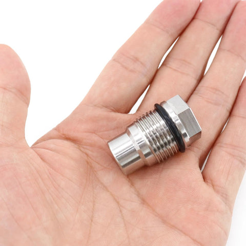Stainless steel fuel rail plug valve, side view, hex end with black O-ring, M20x1.5, held in hand