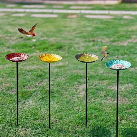 Four flower-shaped metal bird baths with metal stakes in a garden, each bath measures 7.1 inches in diameter and 1.3 inches deep.