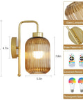 Slick Vintage Gold Wireless Wall Sconces Set Of Two Rechargeable Battery Operated Lights With Amber Stripe Glass Shades And Remote mounted on wall.