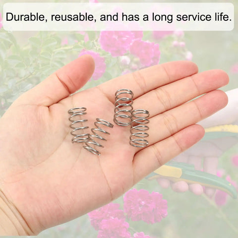 Compression Springs Set, 10 Pack Of 304 Stainless Steel Small Extension Springs, shown in a hand with floral background