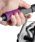 Close-up of hand holding Jellyfish Spinning Reel And Fishing Rod Combo In Purple 5 Foot 6 Inch Medium Two Piece Glass Rod with Gel Tech Grip.