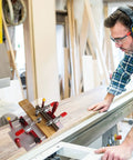 Woodworker uses Coping Sled for Router Table With Clear Acrylic Fence, Rail Guide, Safety Pushing Clamp for precise joints.