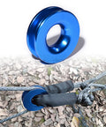 Blue aluminum snatch recovery ring from Four Pack Heavy Duty Green Synthetic Soft Shackle Ropes With 38000 Lbs Breaking Strength And 15000 Lbs WLL Plus Two Blue Aluminum Snatch Recovery Rings For Trailer Truck Snow Plow And Tree Straps Three Eighths And One Half Inch Winch Ropes, shown with green synthetic rope on leaves.