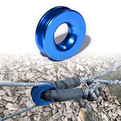 Blue aluminum snatch recovery ring from Four Pack Heavy Duty Green Synthetic Soft Shackle Ropes With 38000 Lbs Breaking Strength And 15000 Lbs WLL Plus Two Blue Aluminum Snatch Recovery Rings For Trailer Truck Snow Plow And Tree Straps Three Eighths And One Half Inch Winch Ropes, shown with green synthetic rope on leaves.