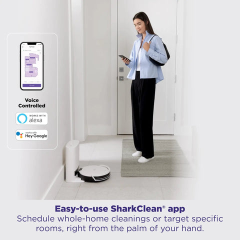 Woman using smartphone app to control Robot Vacuum Cleaner With Beastly Suction For Pet Hair On Rugs And Hard Floors Bagless Self Empty Base For Easy Dump SmartPath LiDAR Navigation For Thorough Room By Room Cleaning And Fresh Floors placed in a room corner.
