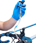 Person using Heavy Duty Hydraulic Bicycle Brake Bleed Kit With DOT Fluid Dual Syringes Quick Connect Hoses on bike handlebar