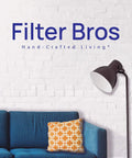 Filter Bros logo on white brick wall with blue sofa and orange pillow