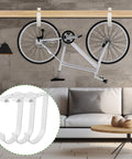 8 Pack Flat Bike Hooks For Garage Storage Elevate Overhead Racks And Wall Shelves Thickened Iron Hangers For Easy Bike Hanging Ceiling Accessory White Finish, with bike mounted on ceiling in a modern room setting.