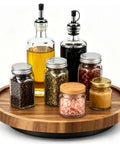 Ten Inch Solid Acacia Wood Lazy Susan With Smooth 360 Swivel Base For Kitchen Counter Organizer Spice Rack Turntable displaying assorted oil and spice jars.