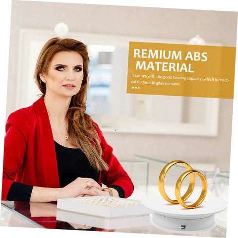 Autonomic Electric Rotating Display Stand For Jewelry Watches And Collectibles With Adjustable Speed showcasing gold rings on counter.