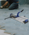 31 Inch Manual Tile Cutter Heavy Duty Precision Scoring Tool With Ball Bearings And Ruler Bar being used to cut tiles on a floor.
