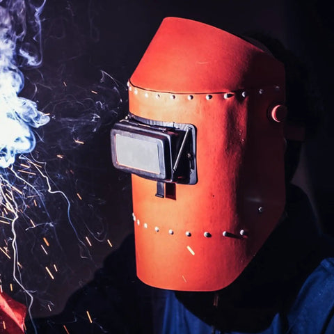 Welding professional using a helmet with premium glass welding lens for safety while cutting and grinding.