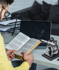 Knight Pen Holder With Two Pens And Resin Desk Organizer For Men on modern office desk with open book and laptop.