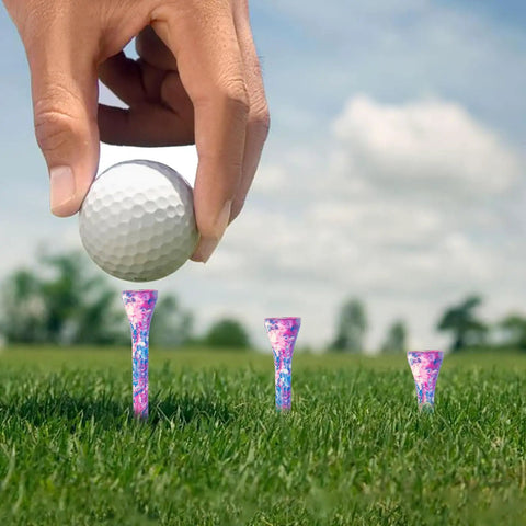 Hand placing golf ball on Durable Hardwood Golf Tees Three And One Quarter Inch Pack Of 100 In Pink And Blue For Women, unbreakable quality