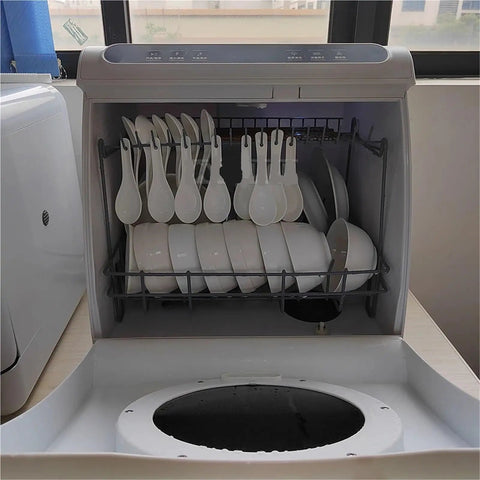 Interior view of Score More Counter Space With This Roomy Portable Countertop Dishwasher filled with plates and spoons.