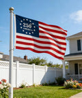 Double Sided 3 Ply 250th Anniversary American Flag 3 By 5 Feet waving on an outdoor flagpole in a residential garden