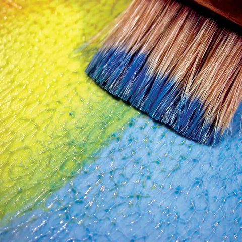 Brush applying Acrylic Glazing Liquid Gloss 8 Oz Bottle for Slow Drying, Maximum Translucency, Extended Working Time, and Precise Blending Control in Acrylic Paints over textured surface