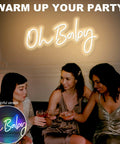 Oh Baby Neon Sign Dimmable LED Neon Light for baby shower backdrop, warm glow, with adapter, used at a party scene.