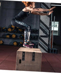Person performing box jumps in a gym with rubber draw latch locks, concealed keeper on the wooden box surface