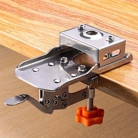 Front view of 35mm hinge boring aid for woodworking, chrome metal with orange adjustment knob clamped to wood edge