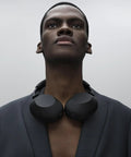 Person wearing black Top Tier Noise Canceling Wireless Headphones With HD NC Processor QN3, 12 Microphones around neck