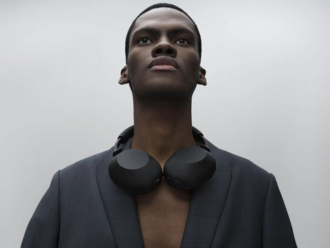 Person wearing black Top Tier Noise Canceling Wireless Headphones With HD NC Processor QN3, 12 Microphones around neck