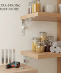 Heavy Duty Stainless Steel Shelf Bracket Wall Mount Built To Last For Garage Kitchen And Bath Storage Secure Stud Mount Level Shelving Support One Pack supporting wood shelf with jars and towels.