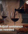Cync Smart LED Candle Bulb B11 With WiFi Control setting ambiance, hand pouring red wine, GE logo visible.