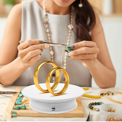 Must Have Electric Rotating Display Turntable With 360 Degree Spin, Auto Speed Control, And Suede Base showcasing jewelry making with golden rings.