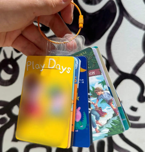 Hand holding colorful cards on loop with Card Organizer For Yoto Cards With 200 Self Adhesive Tabs And 10 Colorful Stainless Steel Loops