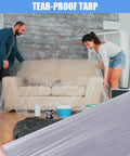 Two people covering a sofa with 30 Pack Clear Plastic Drop Cloths For Painting, Waterproof And Dustproof Protection, Heavy Duty 9x12 Feet Tarps
