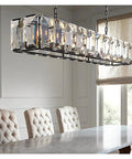 Sleek Modern Black Crystal Ceiling Pendant Light Large Round Hanging Lamp With Polished Stainless Steel Construction above dining table.