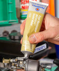 Applying MotoSeal 1 Ultimate Gasket Maker Grey to engine joint, 2.7 oz tube, gasoline resistant, flexible seal on irregular surfaces.