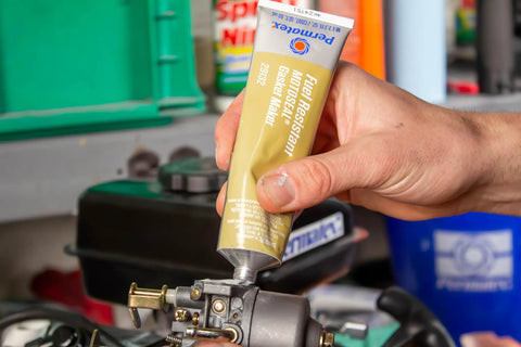 Applying MotoSeal 1 Ultimate Gasket Maker Grey to engine joint, 2.7 oz tube, gasoline resistant, flexible seal on irregular surfaces.