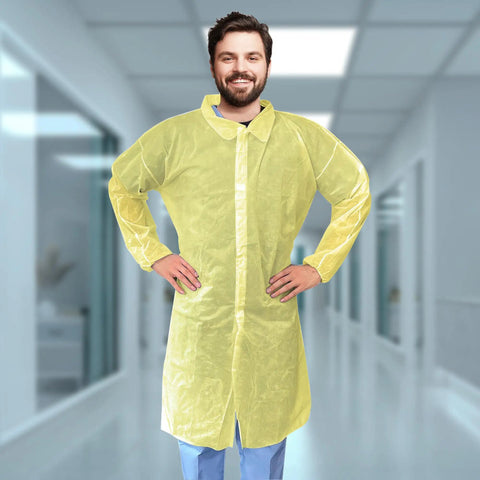 Person wearing Yellow Disposable Lab Coats For Adults XL, 50 Pack, Knee Length, No Pockets, Elastic Wrists, Hook And Loop Closure
