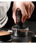 No Drama 2 In 1 Coffee Tamper And Constant Pressure Espresso Distribution Tool With Calibrated Spring For Even Powder Pressing And Flawless Puck Prep In 58mm Silver held in hand, pressing down on espresso basket.