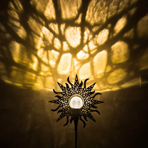 Sun Powered Solar Garden Light Stake With Crackle Glass Metal Finish casting warm glow on wall with sun pattern