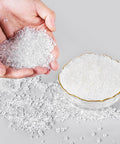 Hands holding Heavy Duty Hot Melt Edgebander Glue Pellets Straight Up Premium EVA Formula with clear adhesive granules.