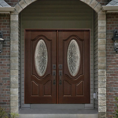 Double front doors with oval glass panels and bronze handles, set in a brick entryway with stone arch detailing.